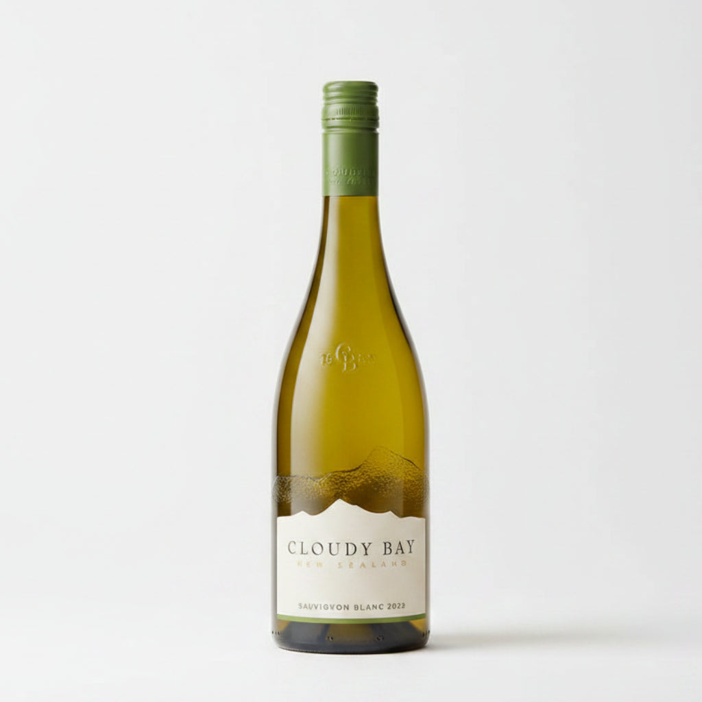 A bottle of Cloudy Bay White Sauvignon Blanc wine stands upright against a rustic stone wall background.